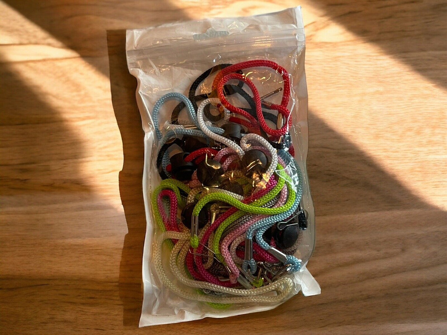 10 pack lanyards assorted colors in clear plastic bag with metal clips on wooden surface