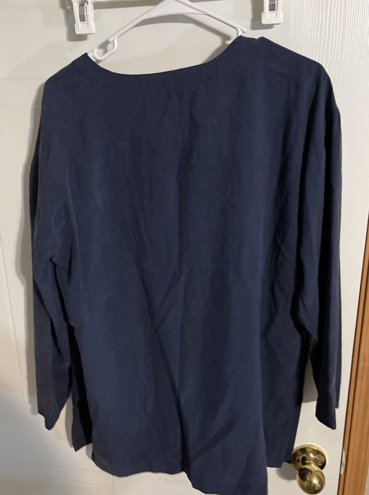 Navy blue long sleeve top hanging on white hanger showcasing 1010 Design silk loungewear from 1118 Emporium