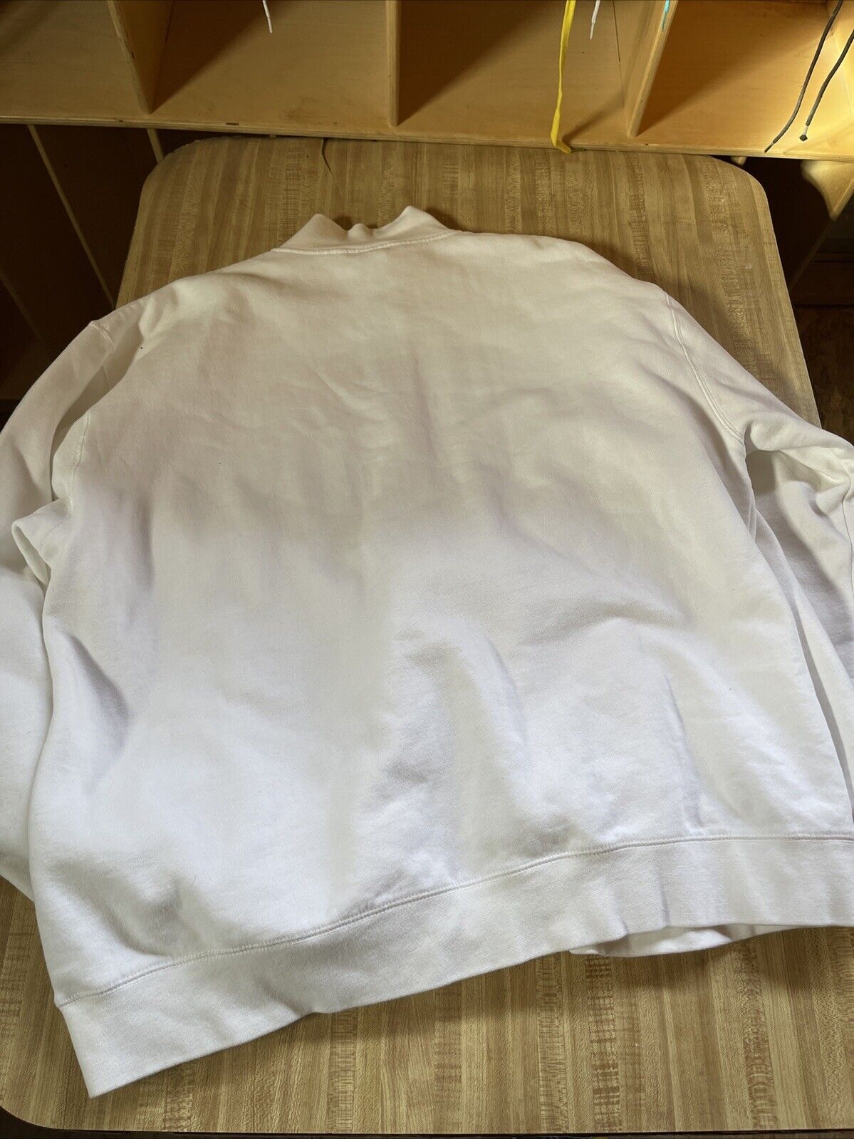 Back view of a white 2XL Fiat jacket laid flat on a wooden surface from 1118 Emporium