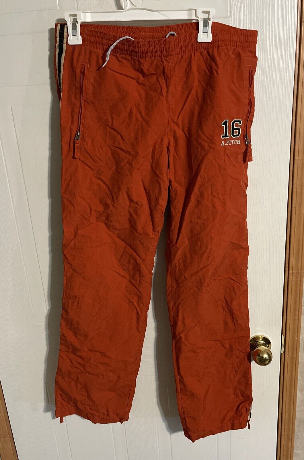 Abercrombie windbreaker pants small in burnt orange with zipper pockets and logo number 16 on side