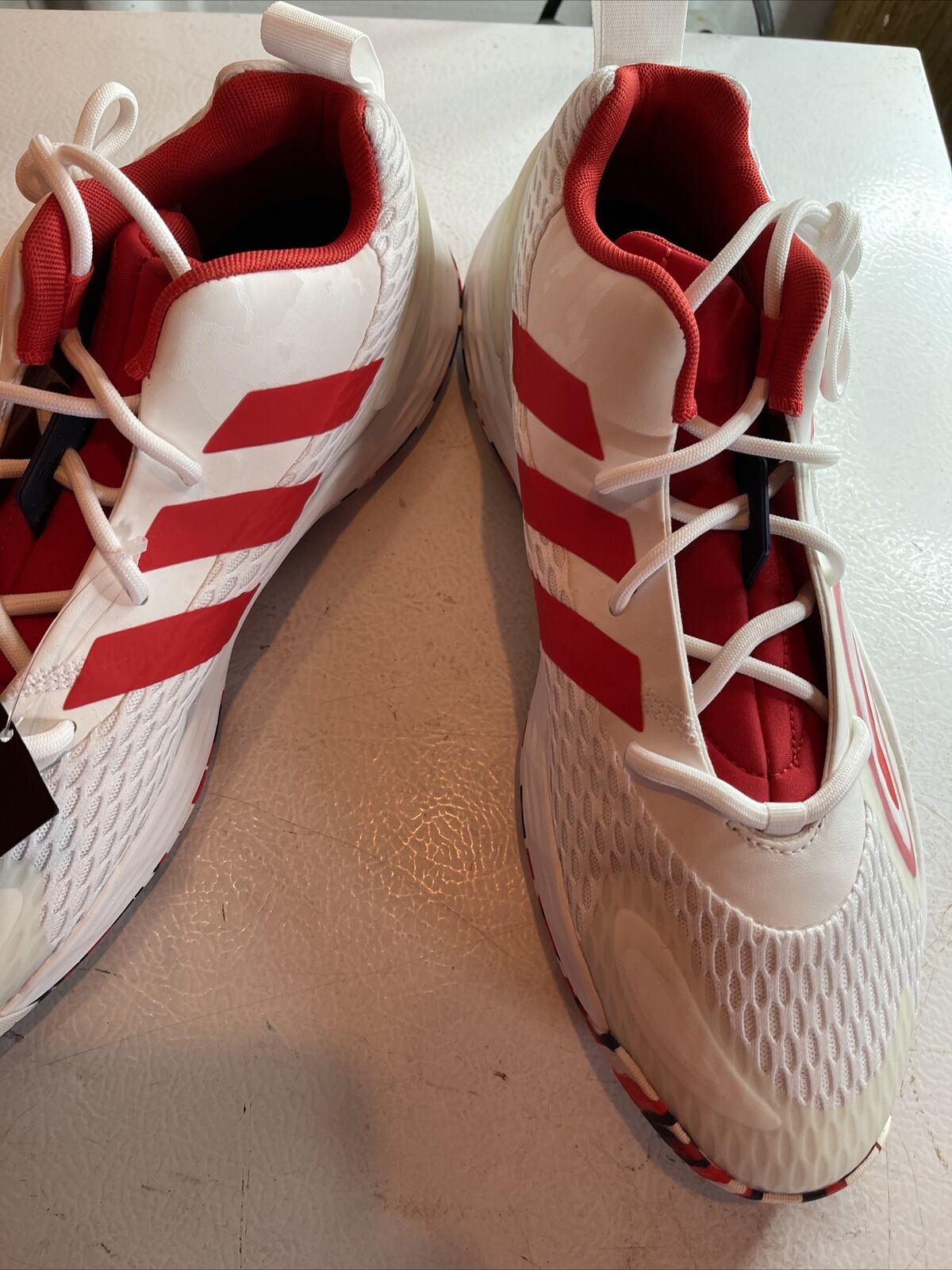 White and red Adidas SM Exhibit A Team USA sneakers with mesh texture and lace-up design