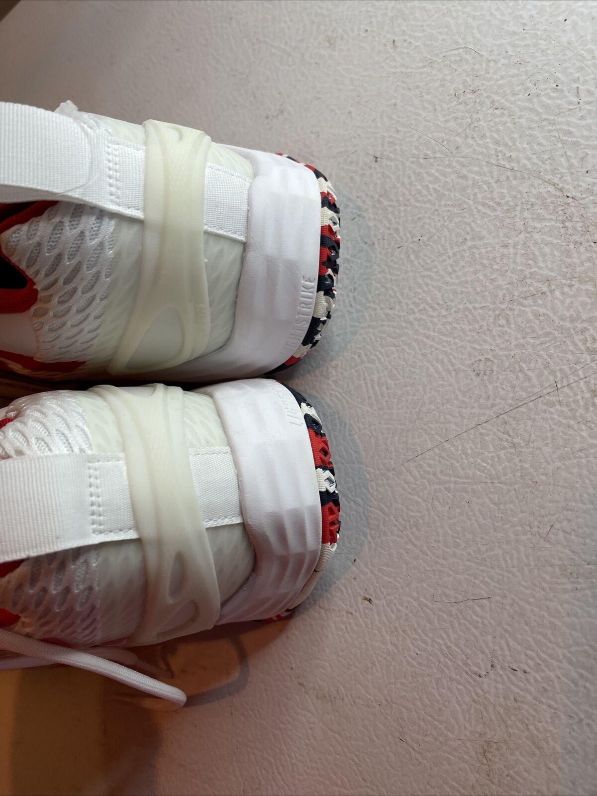 Close-up view of Adidas SM Exhibit A Team USA sneakers with white mesh and red accents