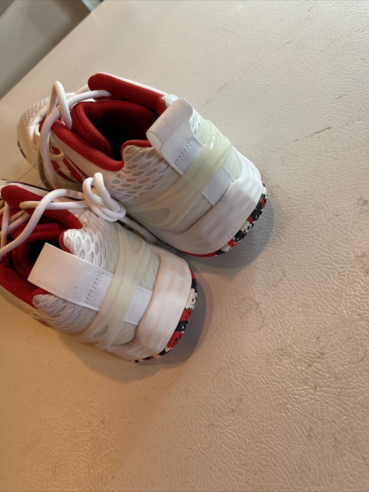 Back view of white and red Adidas SM Exhibit A Team USA sneakers with textured heel and patterned sole