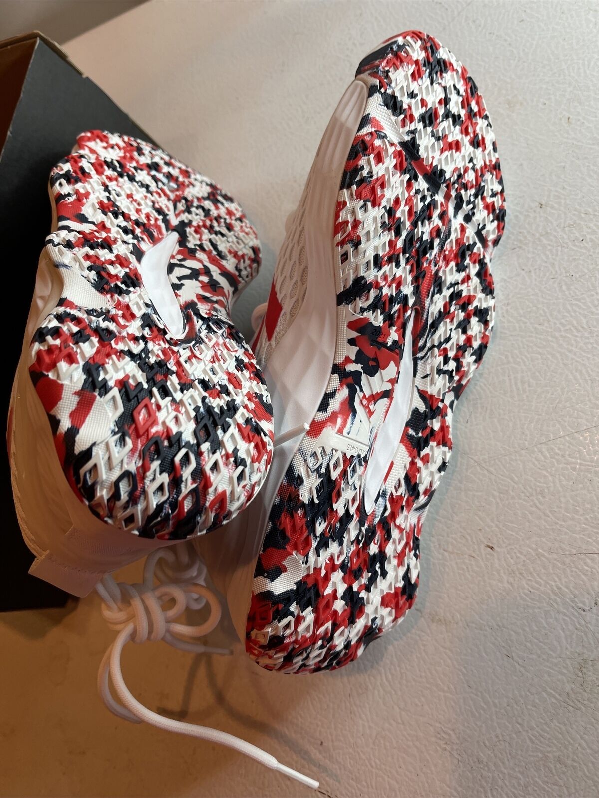 Adidas SM Exhibit A Team USA sneakers showing red black and white patterned soles and white upper material