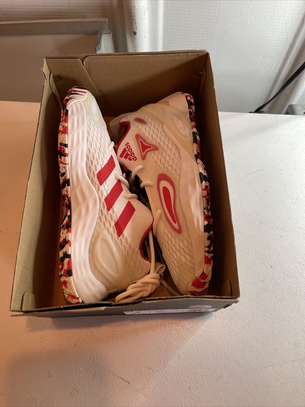 Adidas SM Exhibit A Team USA sneakers in white with red and black camo sole inside a cardboard box