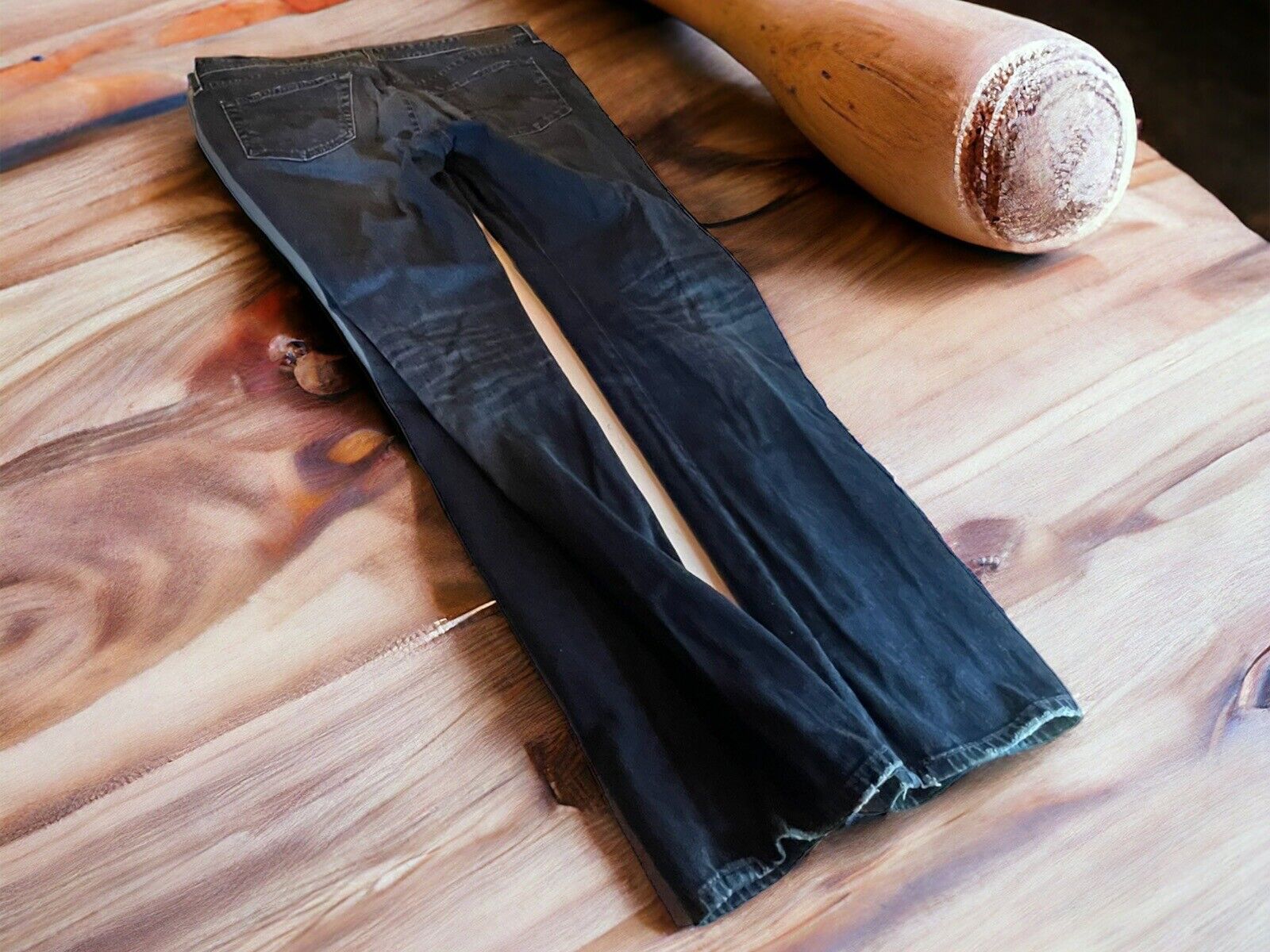 Adriano Goldschmied Everett jeans in black laid flat on wooden surface next to wooden bat