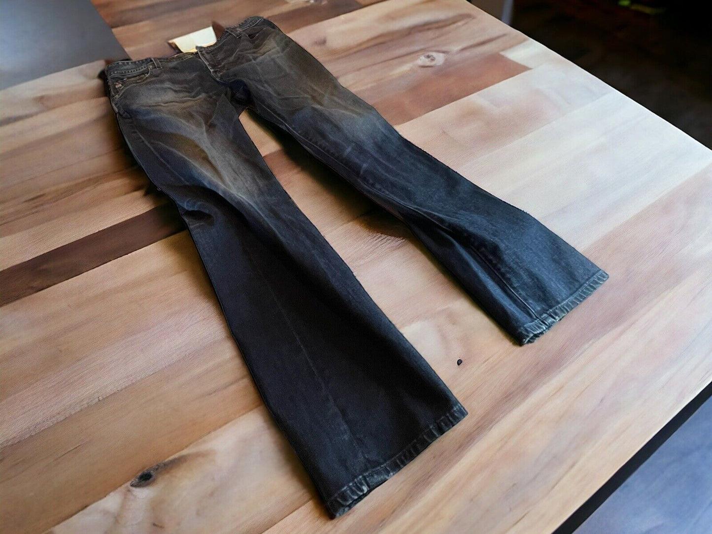 Adriano Goldschmied Everett jeans in dark wash laid flat on wooden table showing full length and faded details