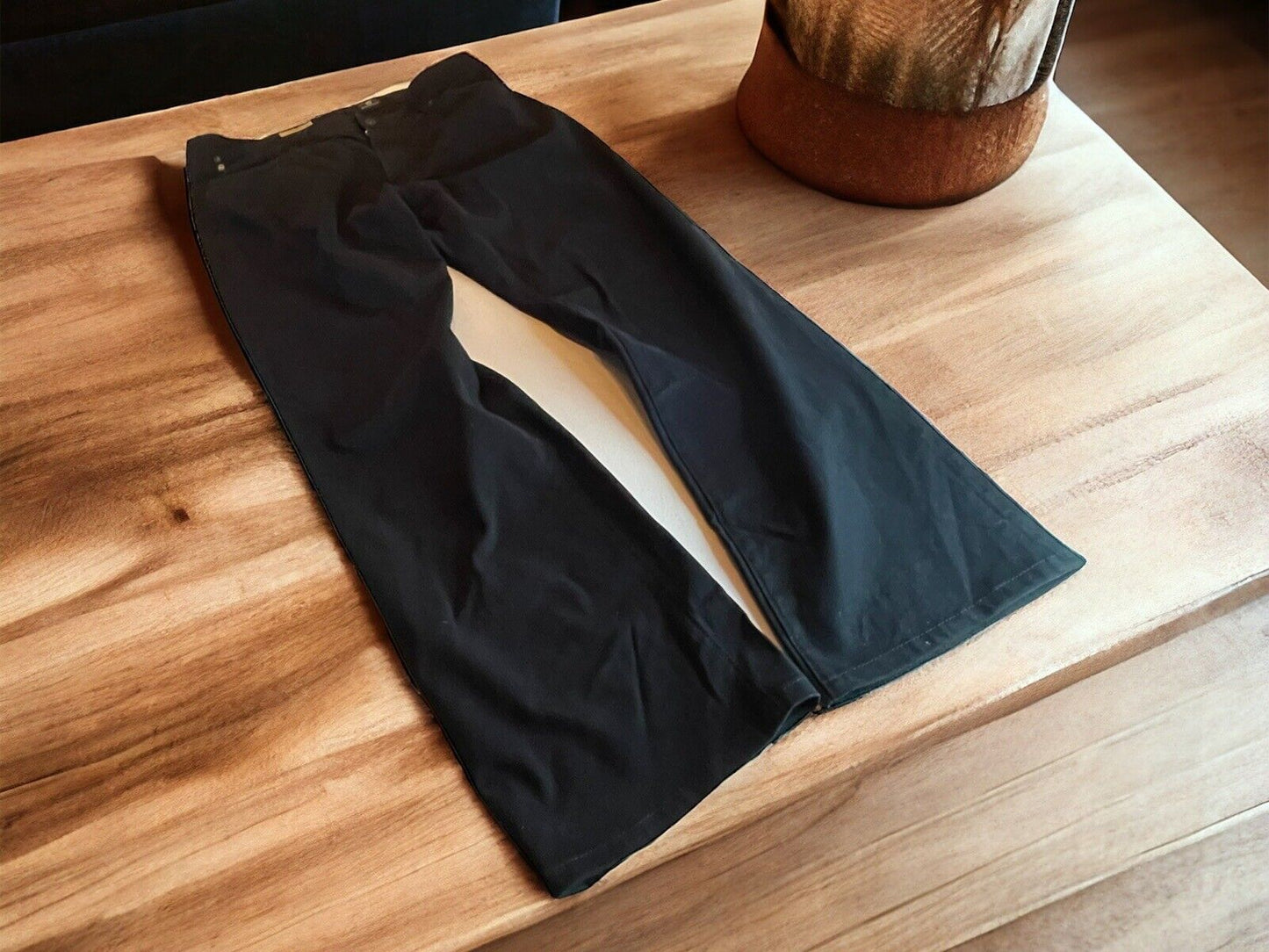 Adriano Goldschmied The Protege jeans laid flat on a wooden surface near a rustic decor item