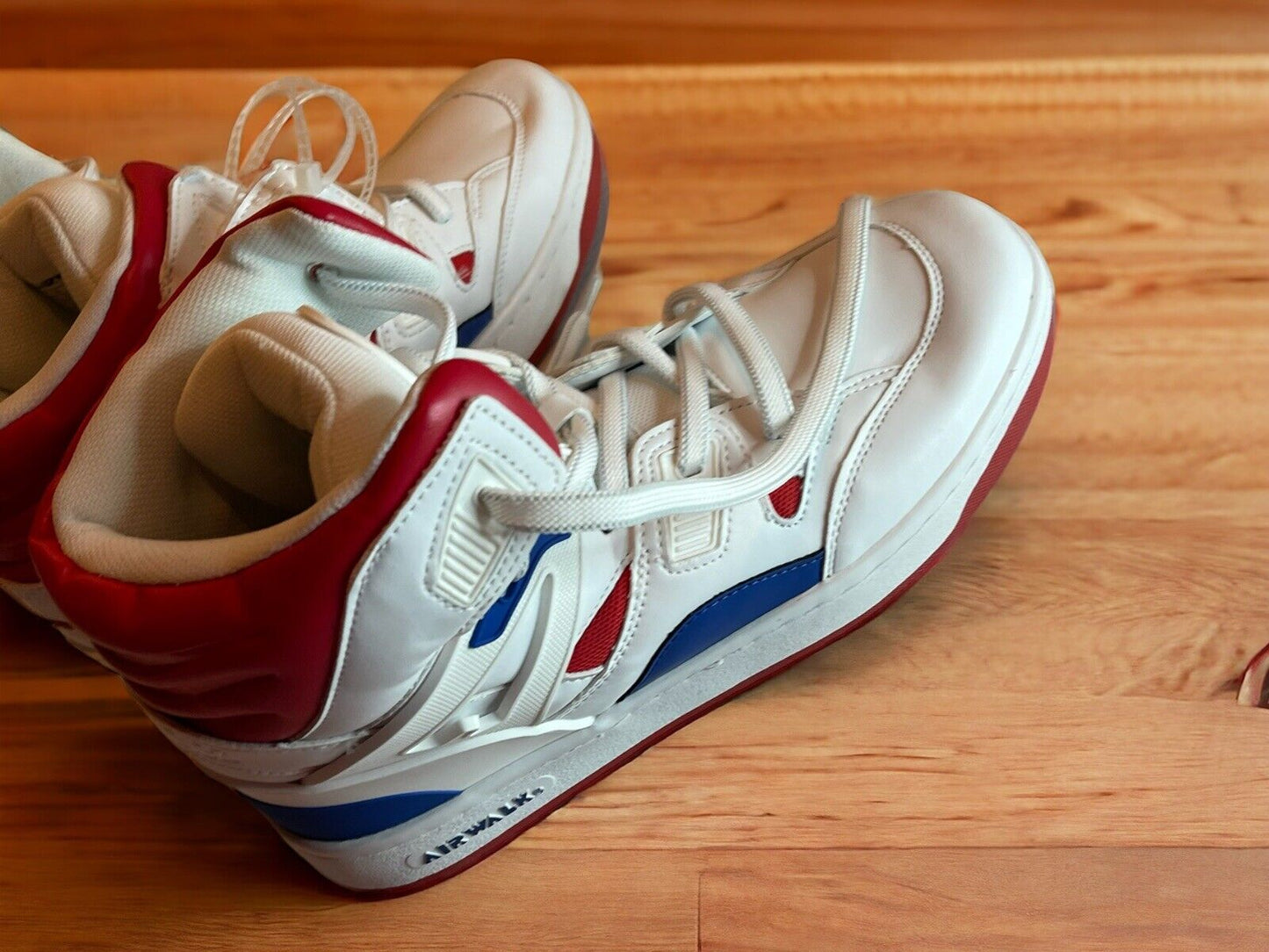 White and red Airwalk men’s sneakers size 10 with blue accents on wooden floor