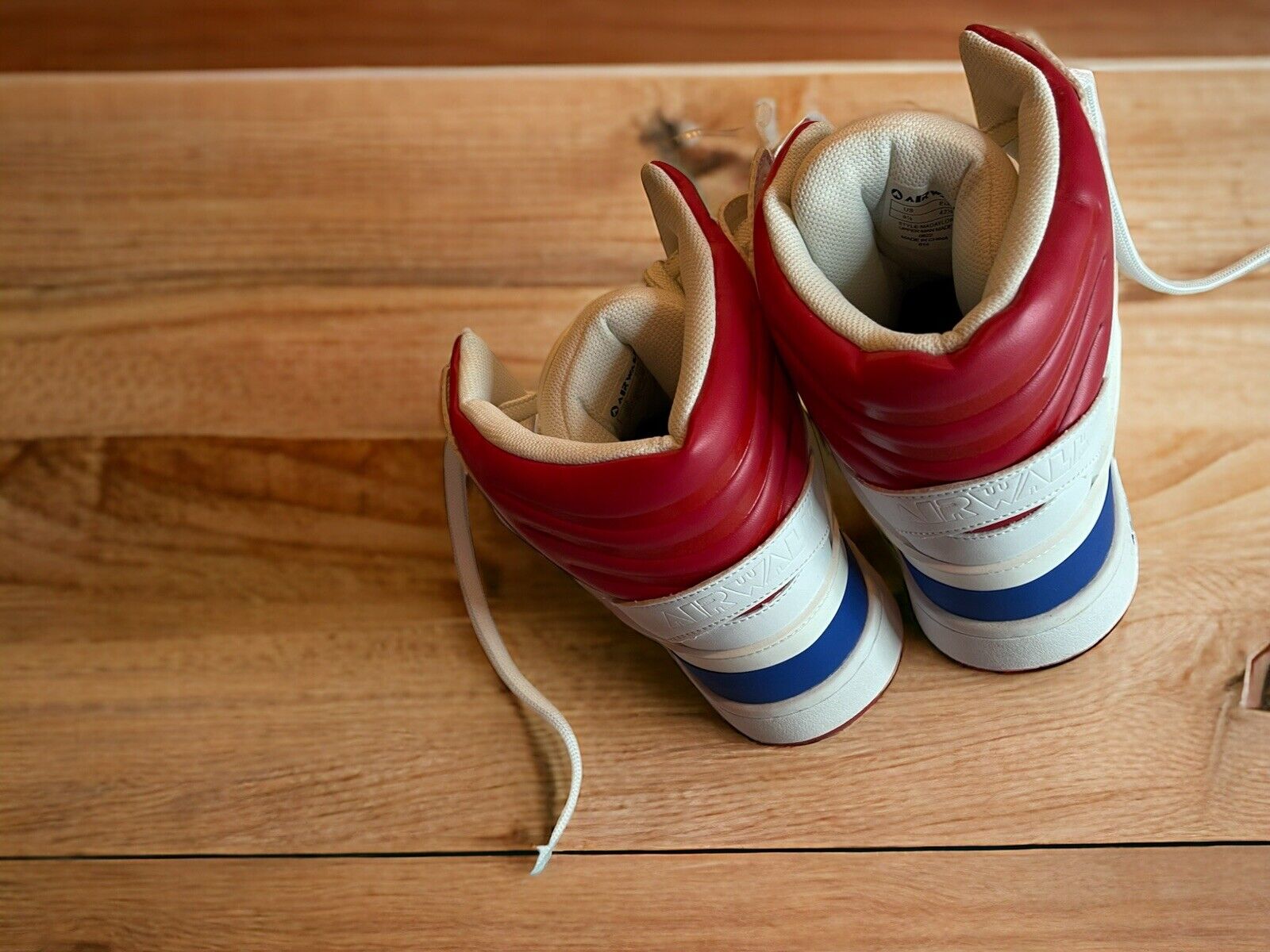 Airwalk men’s sneakers size 9.5 in red white and blue displayed on wooden floor from the back