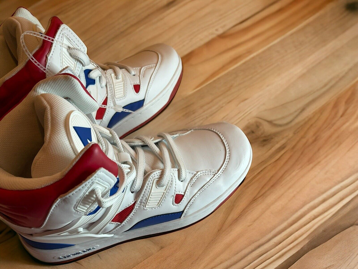 White high-top Airwalk sneakers size 8.5 with red and blue accents on wooden floor