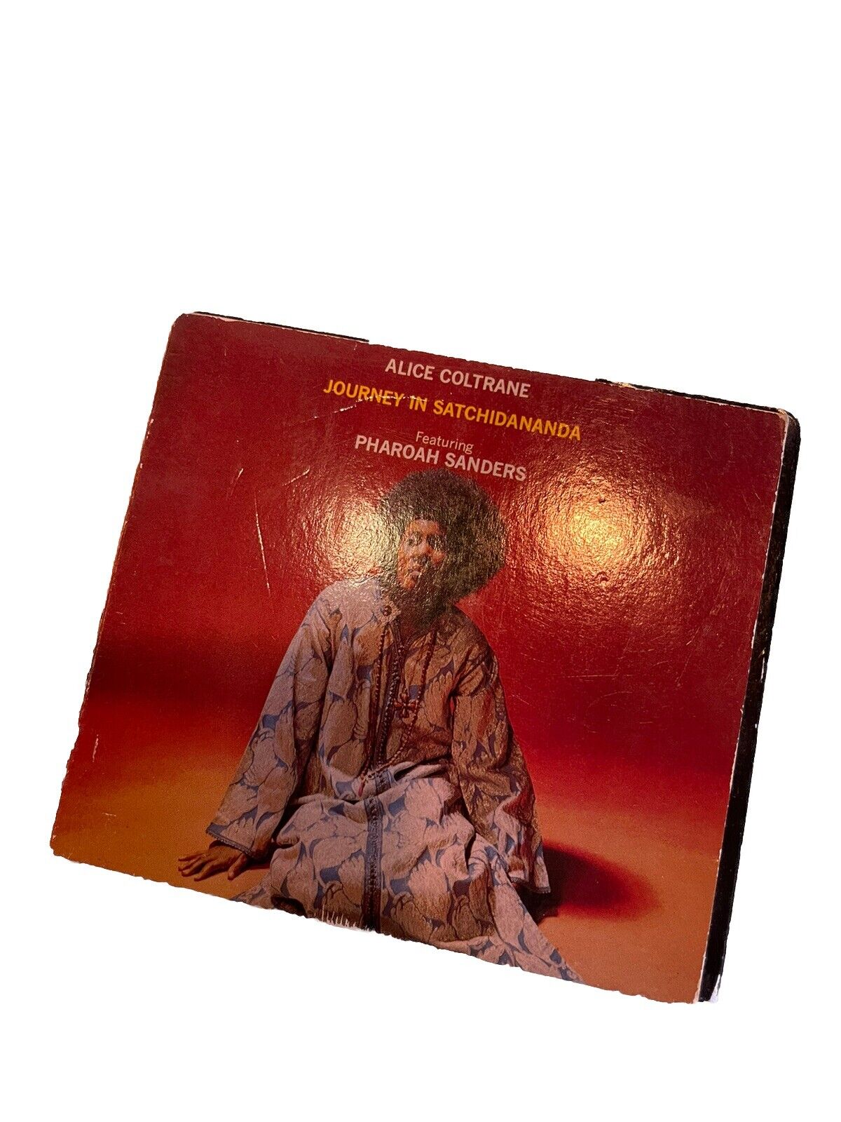 Alice Coltrane Journey in Satchidananda CD album cover featuring Alice Coltrane in a patterned robe on red background