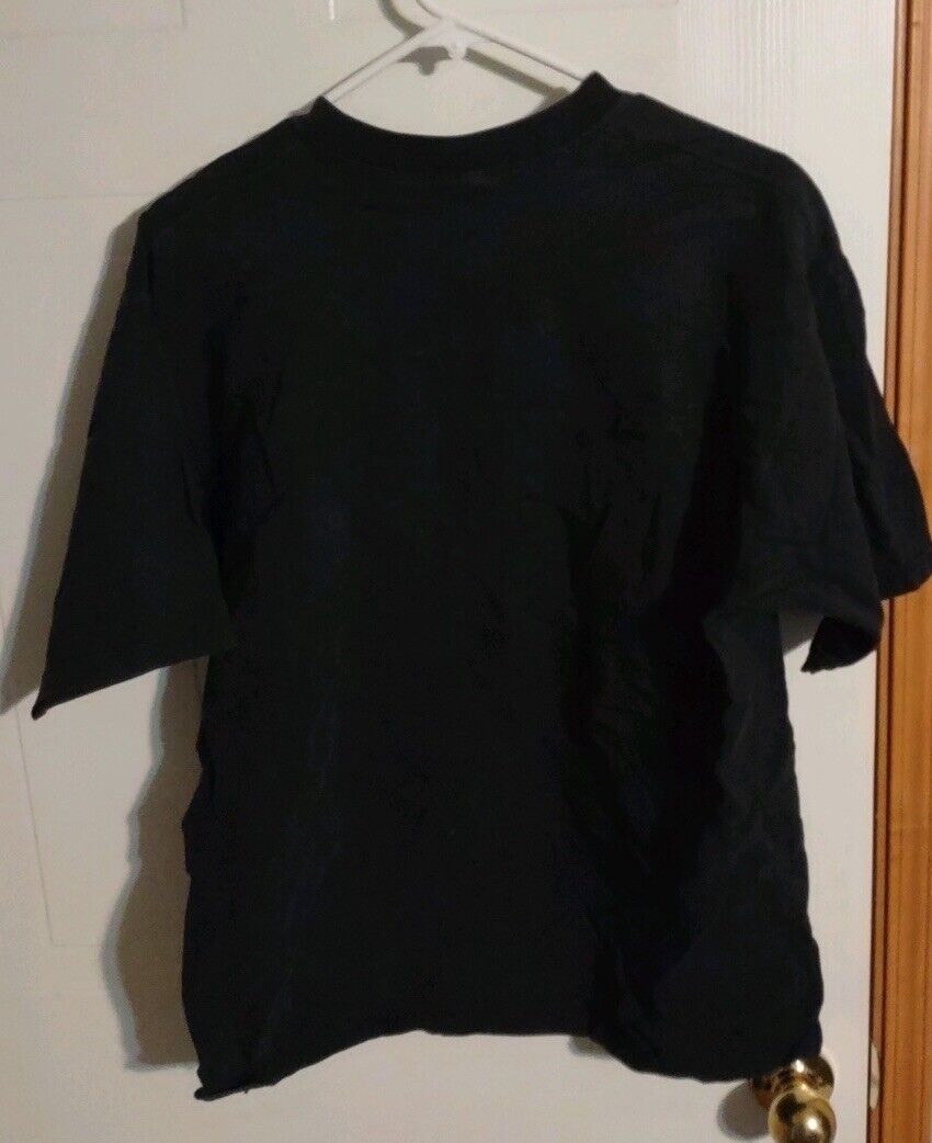 Black Americade Lake George t-shirt hanging on hanger against white door background