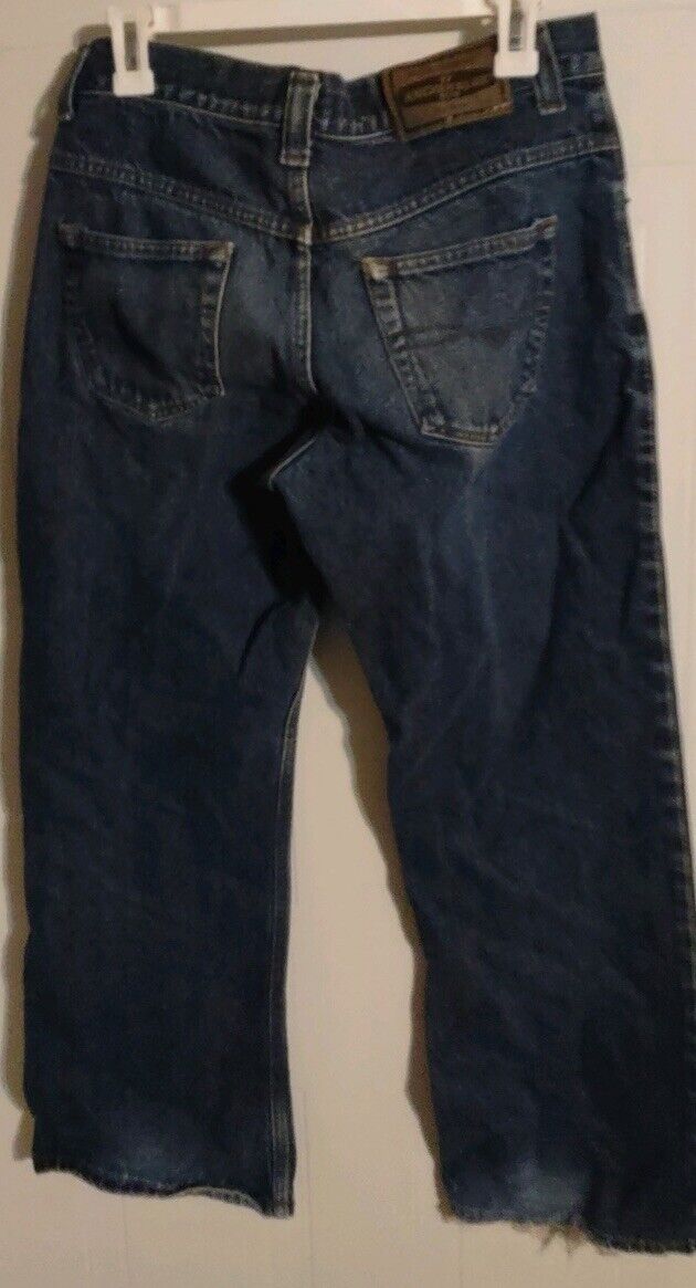 Anchor Blue bootcut jeans in dark wash with rear pockets and frayed hems hanging on clips