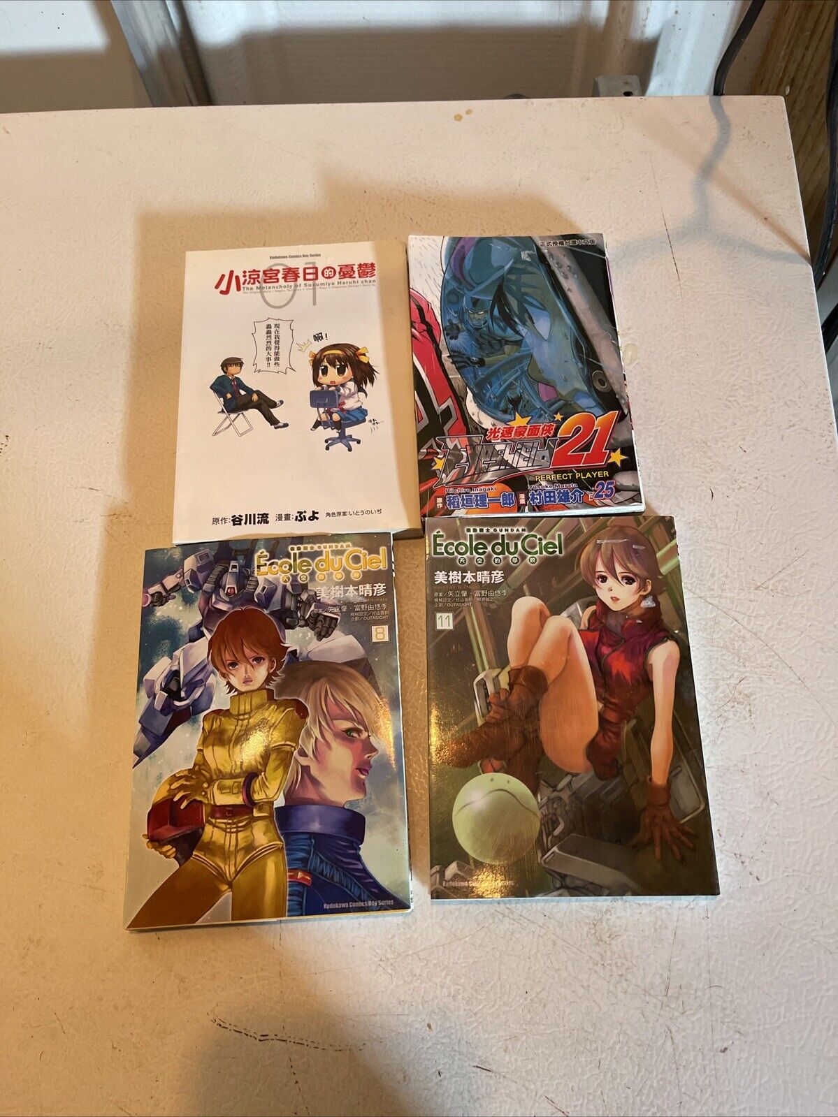 Anime book lot for sale featuring four manga volumes with colorful covers on a light surface