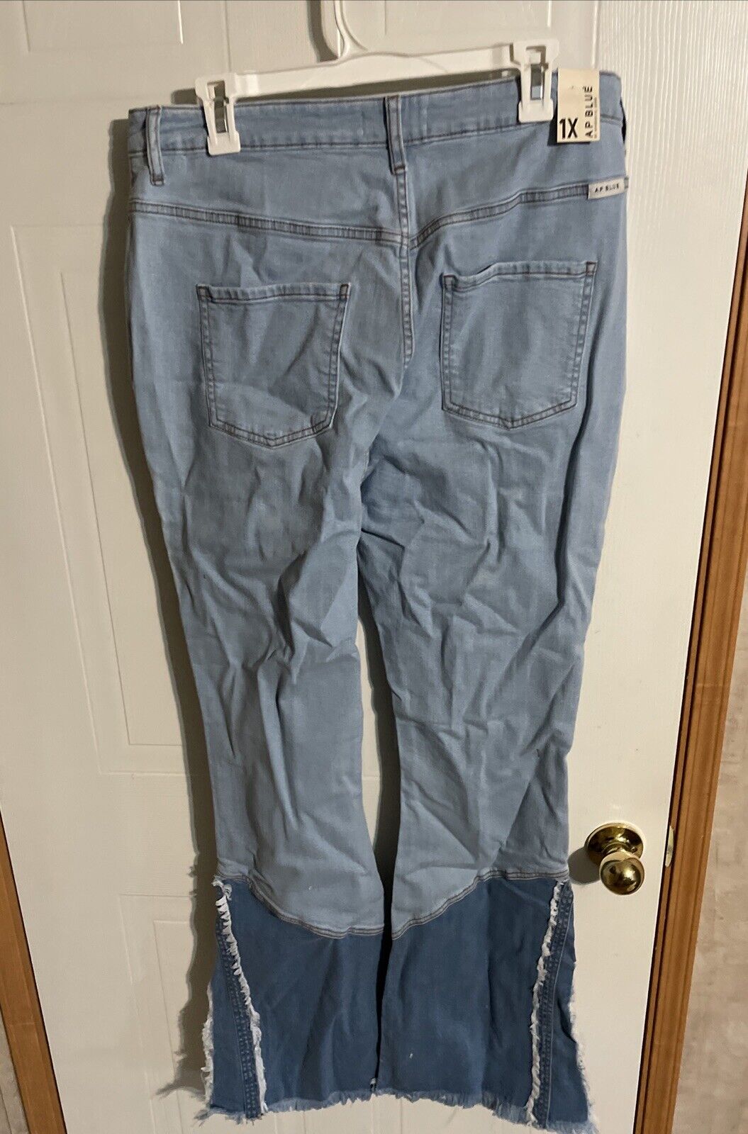AP brand 1XL trendy jeans in light blue denim with dark blue frayed hem detail hanging on white hanger