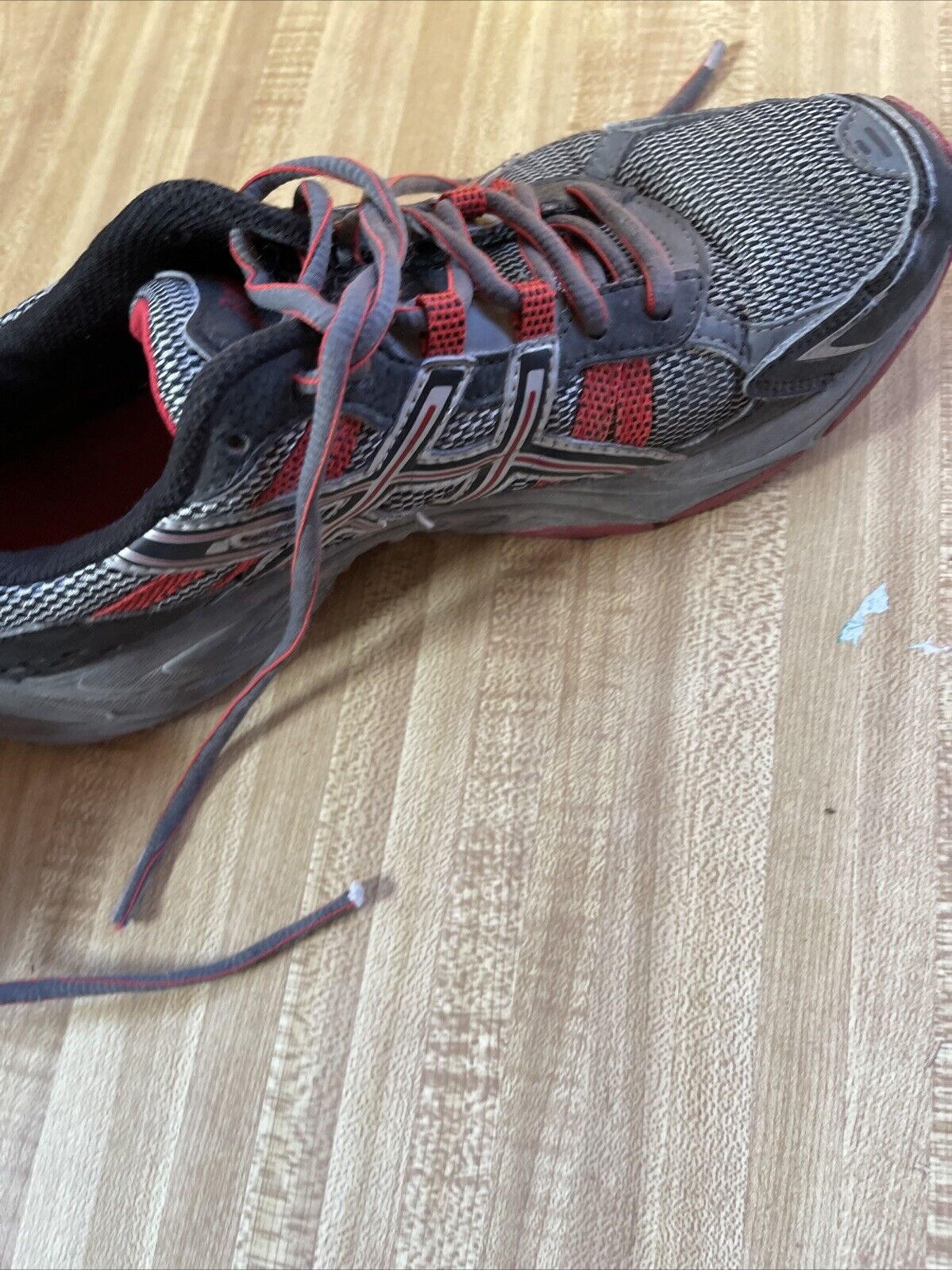 ASICS Gel Venture 4 men’s size 12 running shoe in black and red on wooden floor