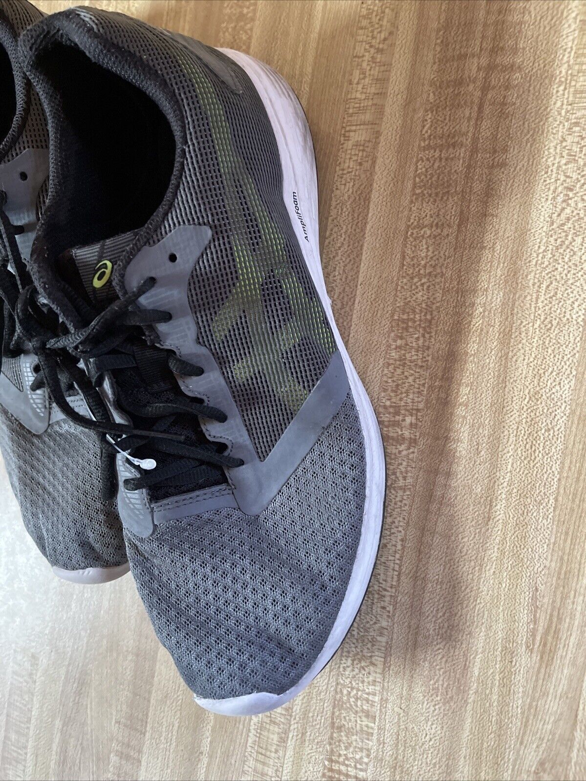 Gray and black ASICS Patriot 10 men’s running shoes with breathable mesh and white soles