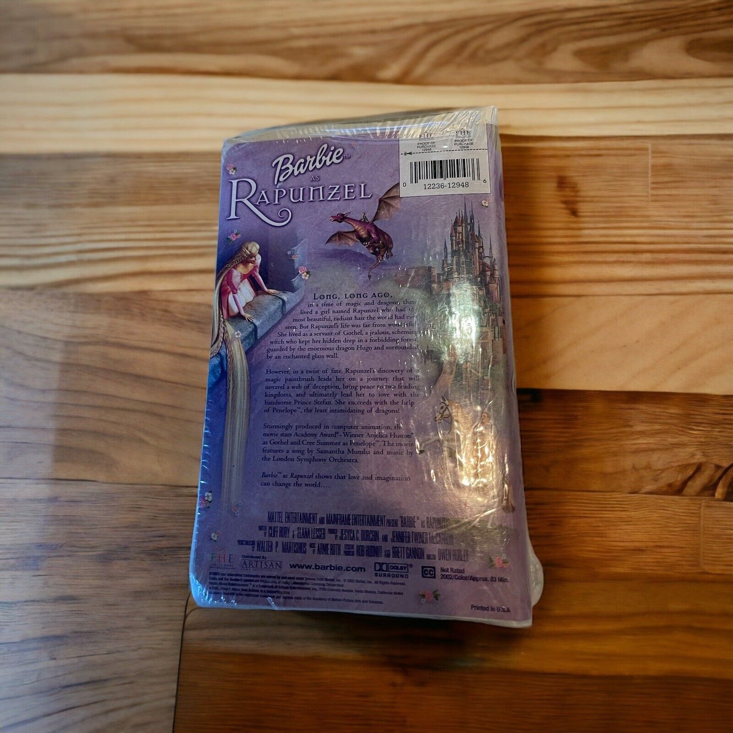 Back cover of Barbie as Rapunzel VHS with purple artwork and story description wrapped in plastic