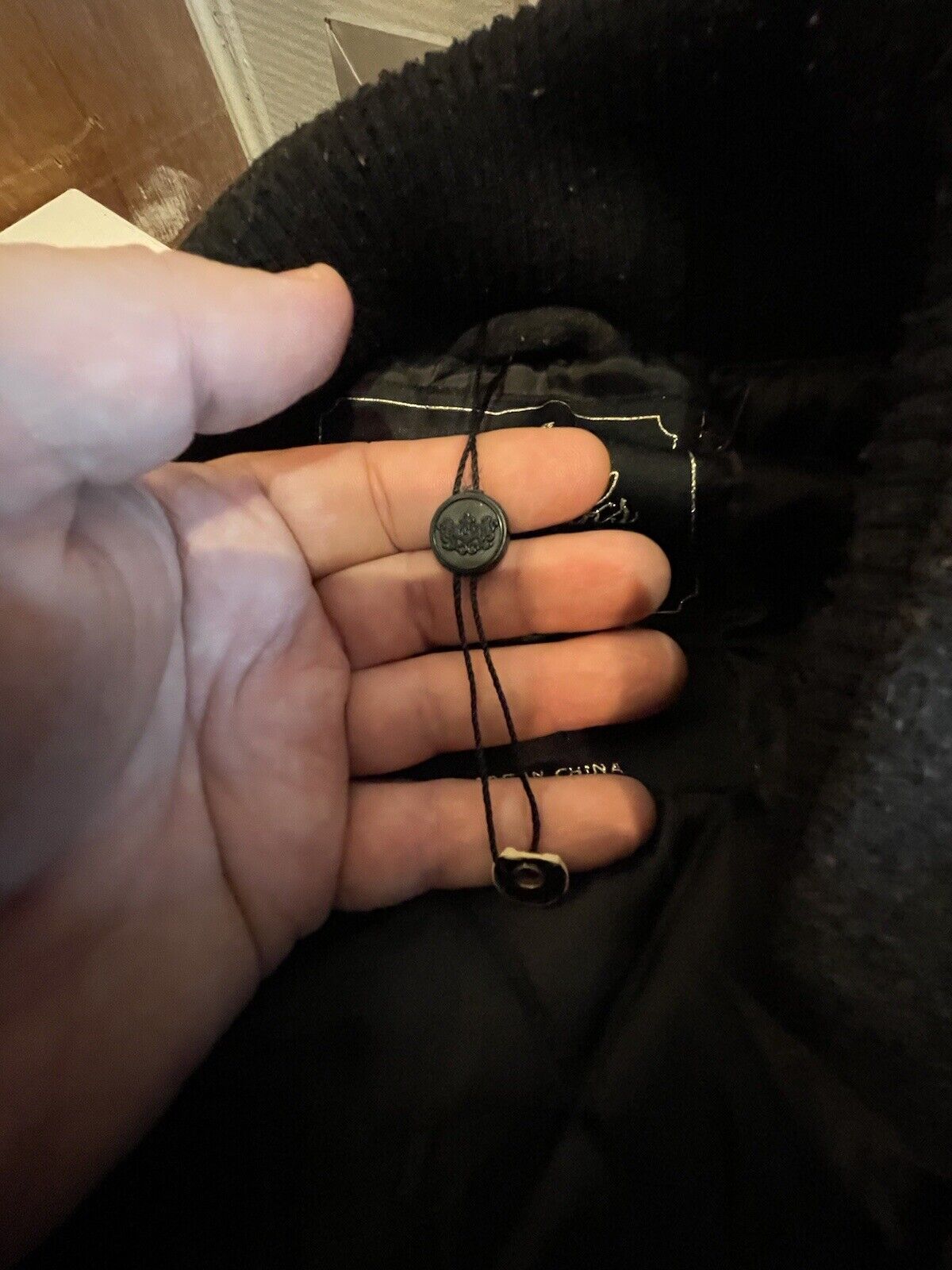 Close-up view of adjustable string detail inside XXL hip hop fashion jacket by 1118 Emporium in black fabric