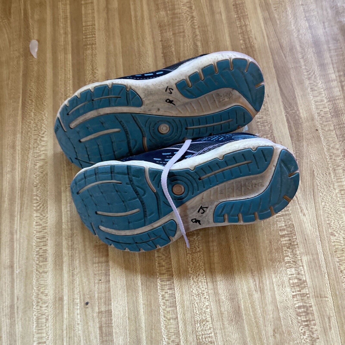 Brooks Glycerin GTS 20 women’s size 7 running shoes showing blue and white tread soles on wooden floor