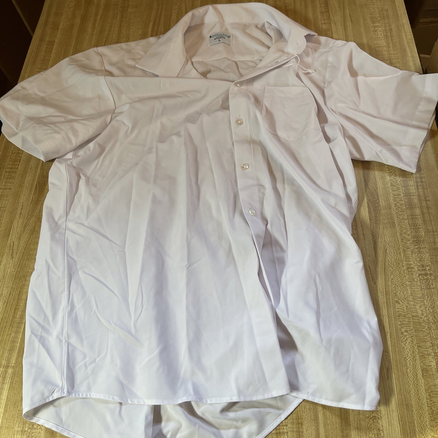 White men's athletic button up shirt from & Collar laid flat on wooden surface