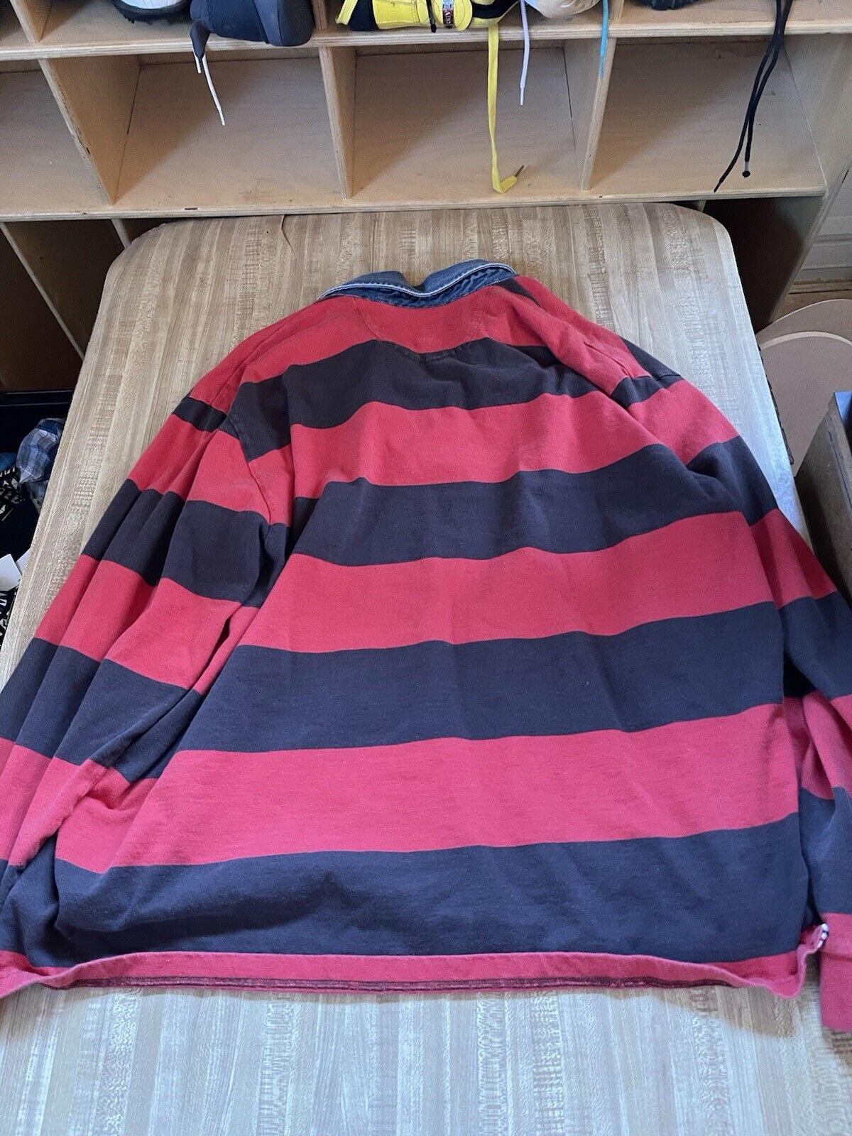 Men's striped rugby shirt XXL in red and black horizontal stripes laid flat on bed