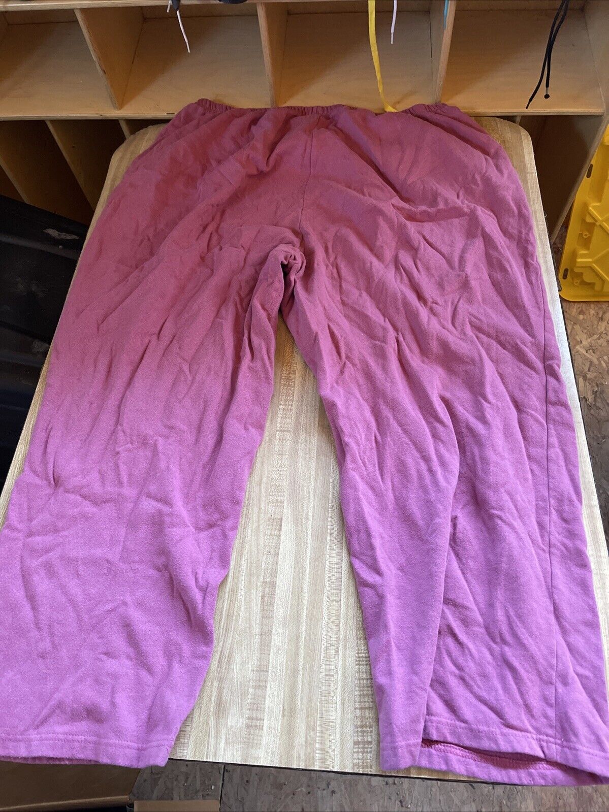Pink plus size sweatpants 4XL laid flat on a wooden surface with an elastic waistband