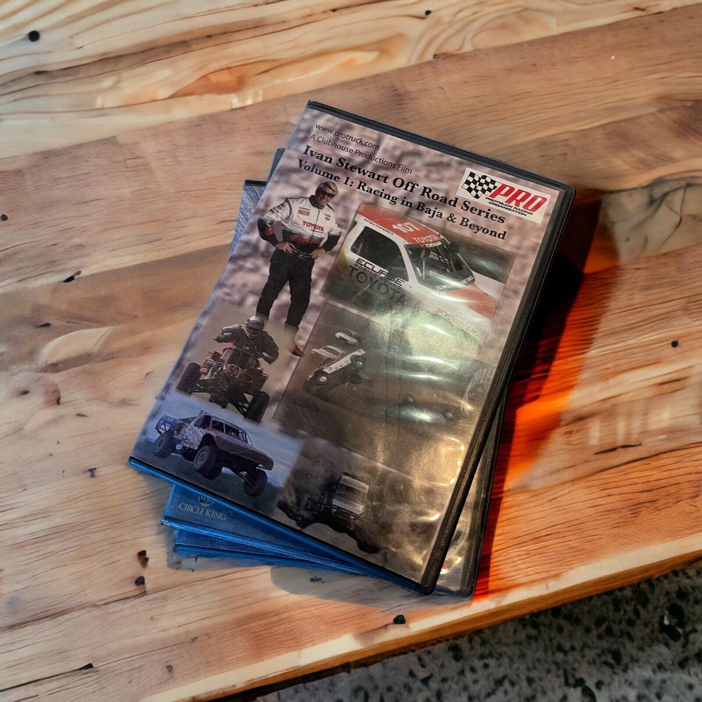 Stack of monster truck dvd collection cases featuring off-road racing and trucks on wooden table
