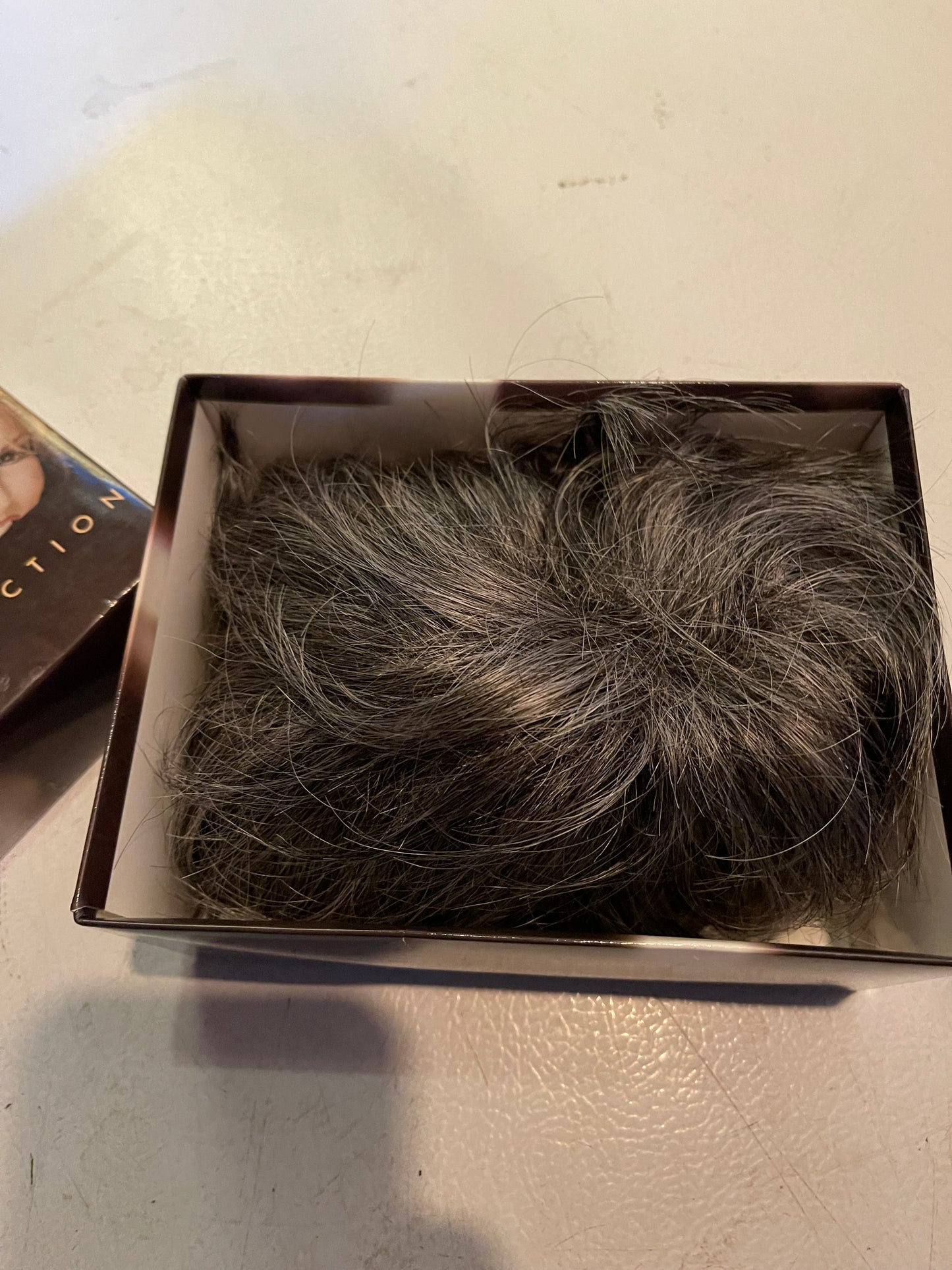 Luxury women’s wigs realistic dark brown with gray highlights in a black storage box