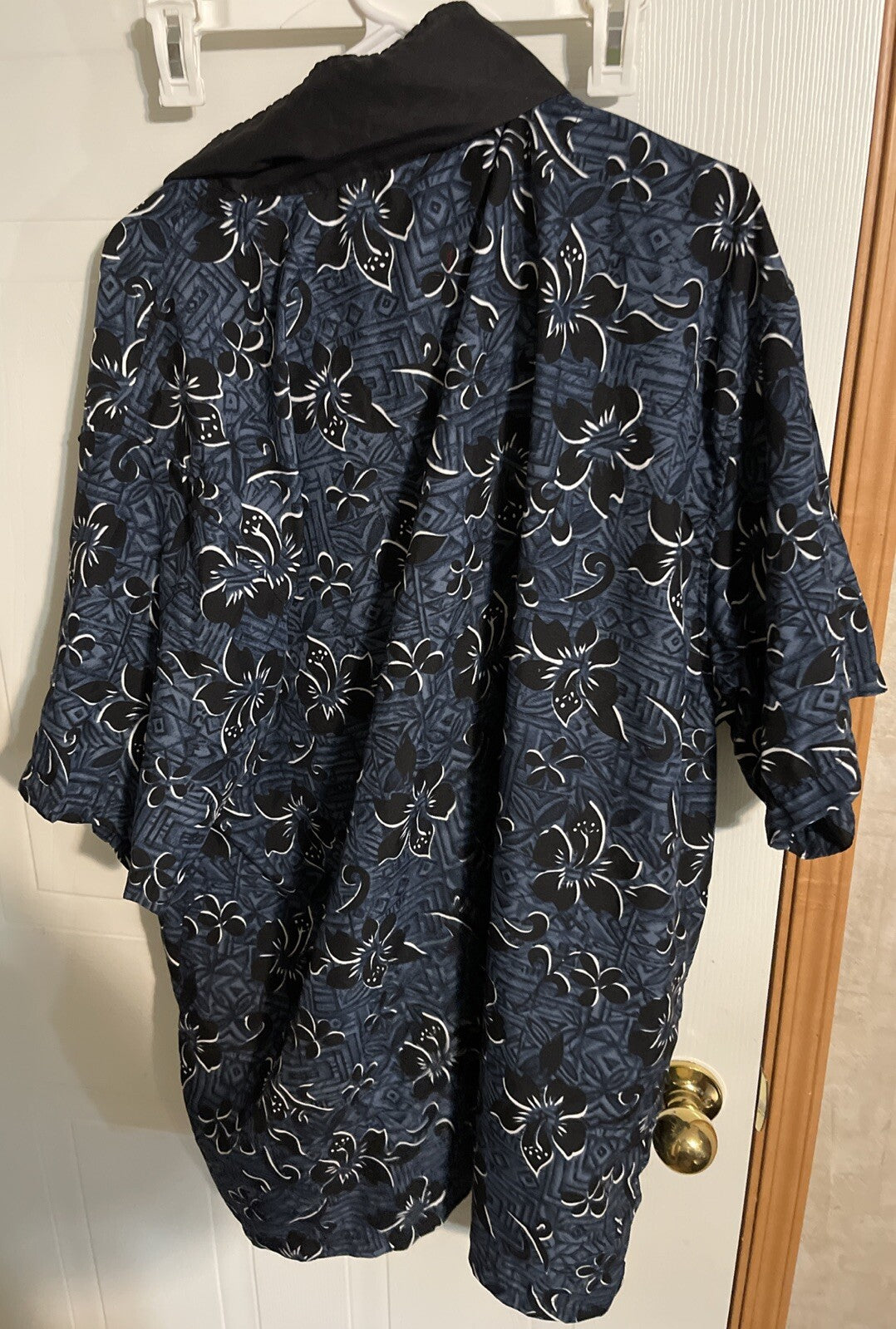 Zero gravity Hawaiian shirt XL in dark blue with black and white floral patterns hanging on a door