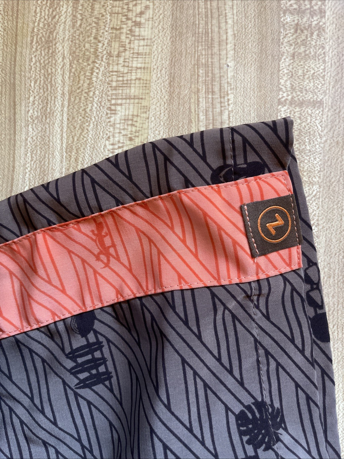Close-up of Zippy's Hawaiian shirt large with black and coral patterned fabric and logo tag