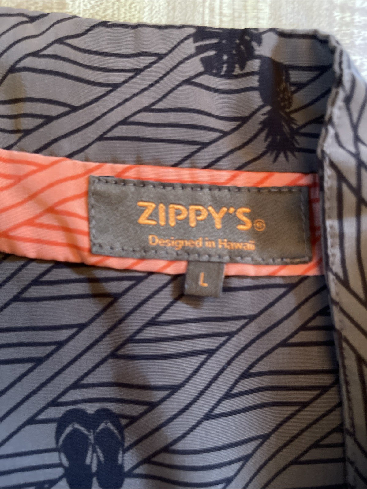 Zippy's Hawaiian shirt large size label stitched on patterned fabric with tropical design