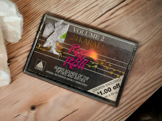 24 karat rock and roll cassette tape Volume 2 with coupon on wooden surface