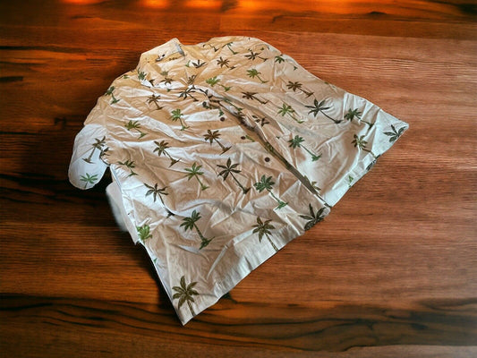 Wrinkled 4XL Hawaiian shirt with green and brown palm tree patterns lying on wooden surface
