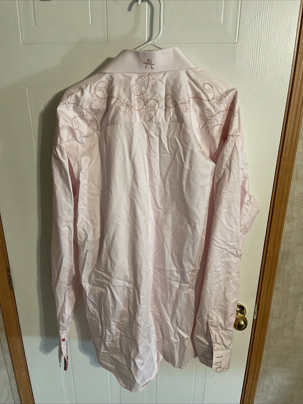 Light pink 5XL dress shirt for men hanging on white door with embroidered back design