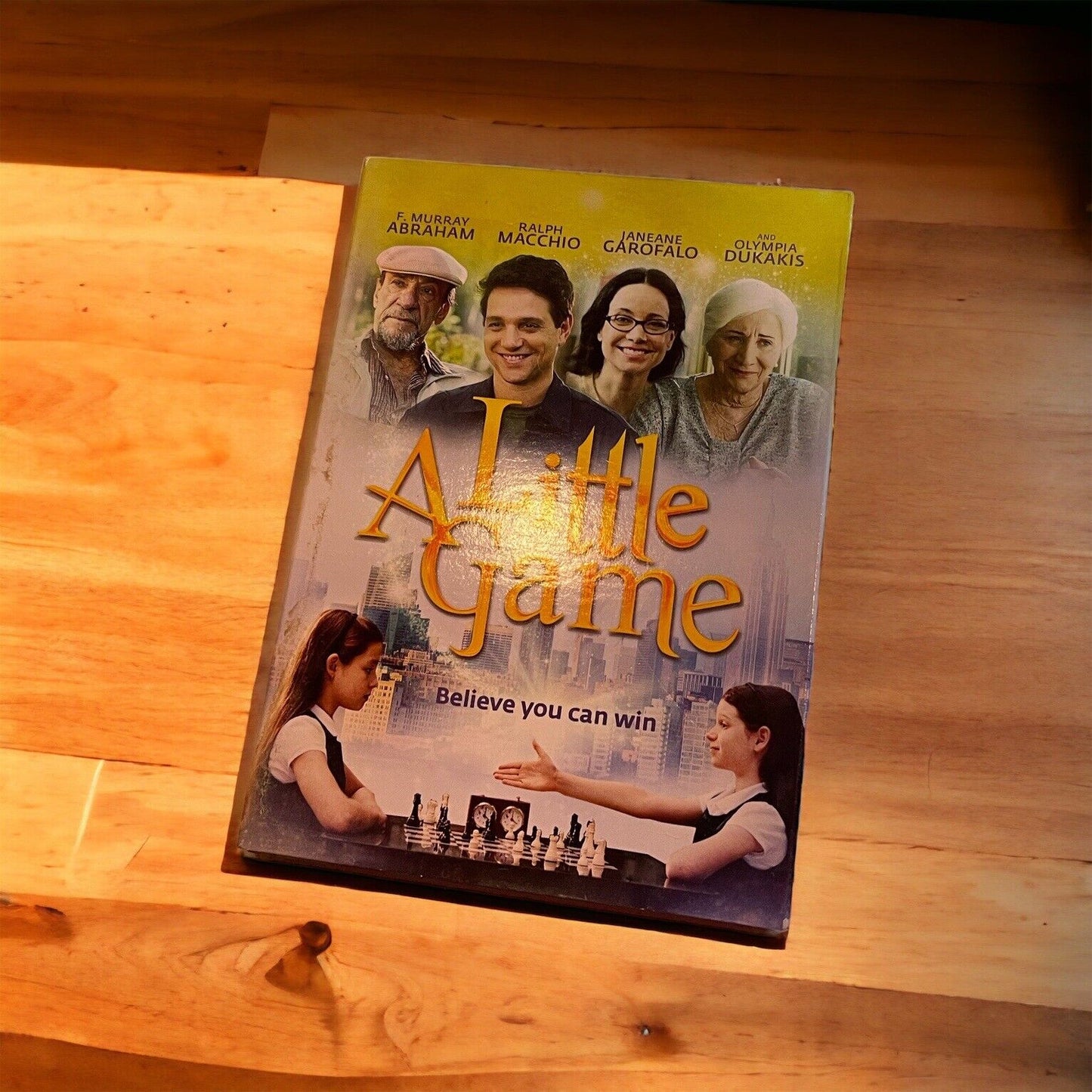 A Little Game family movie DVD cover featuring cast and chessboard scene on wooden surface