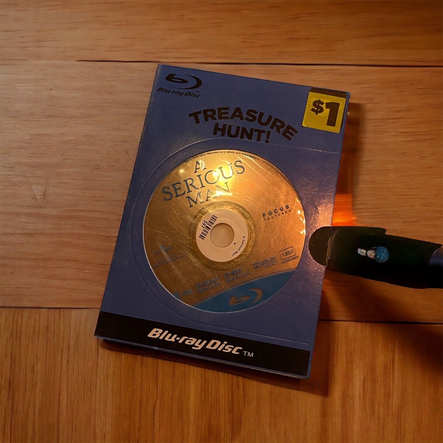 A Serious Man Blu-ray 2009 in Treasure Hunt case with $1 price tag on wooden surface