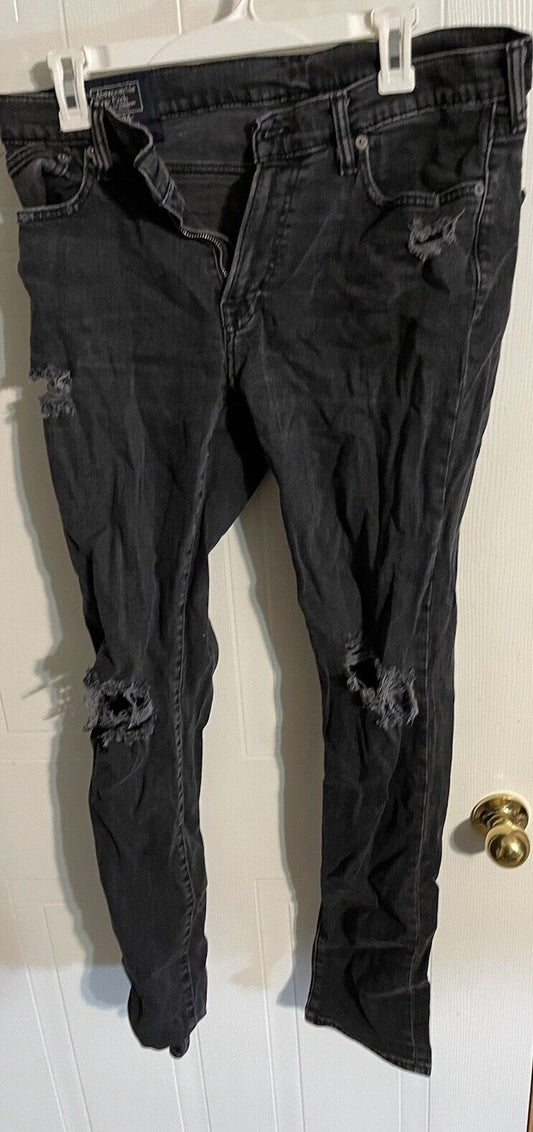 Black distressed Abercrombie Fitch Langdon slim jeans hanging on white hanger with ripped details