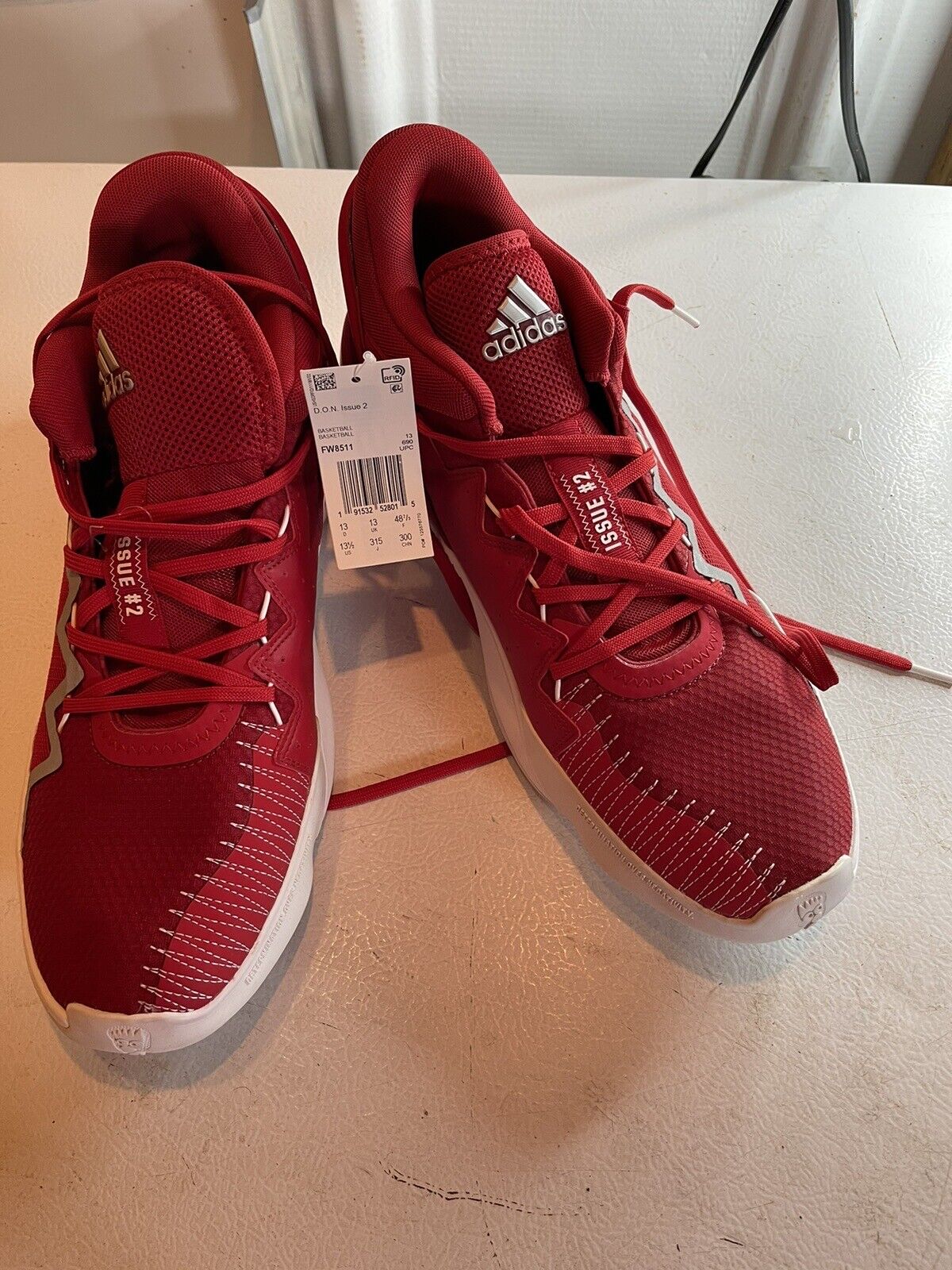 Red adidas d.o.n. issue 2 size 13.5 basketball shoes with white soles and laces on table