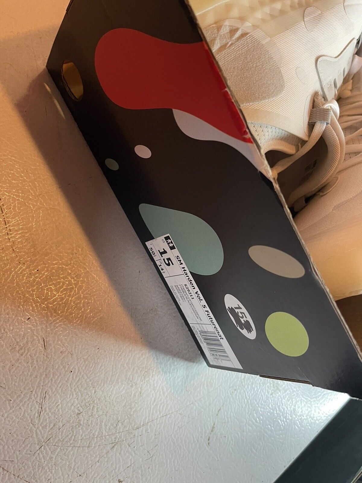 Adidas Harden Vol 5 Futurenatural shoebox in size 15 next to partially visible white sneakers