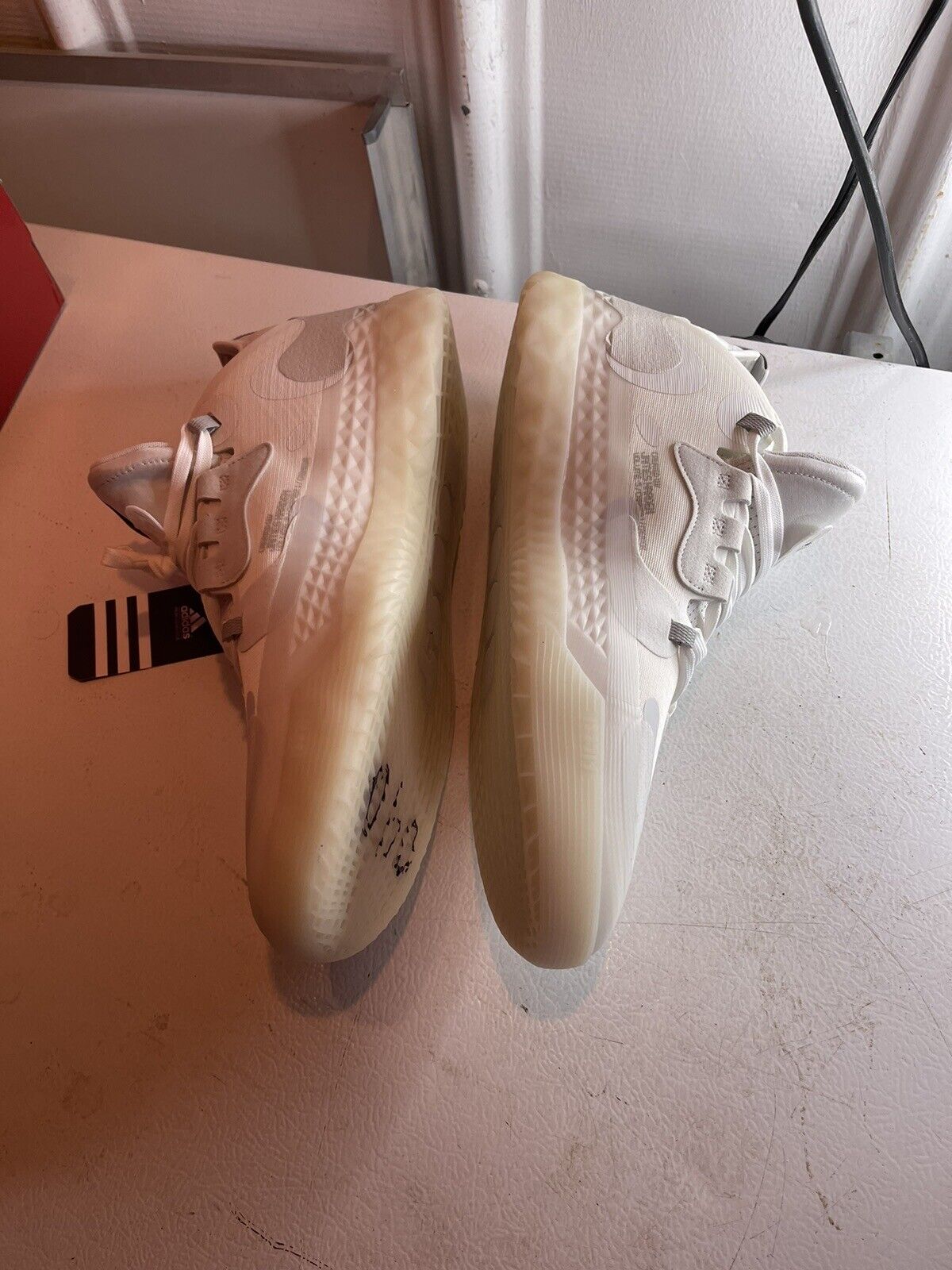 Pair of white Adidas Harden Vol 5 Futurenatural basketball shoes with translucent soles