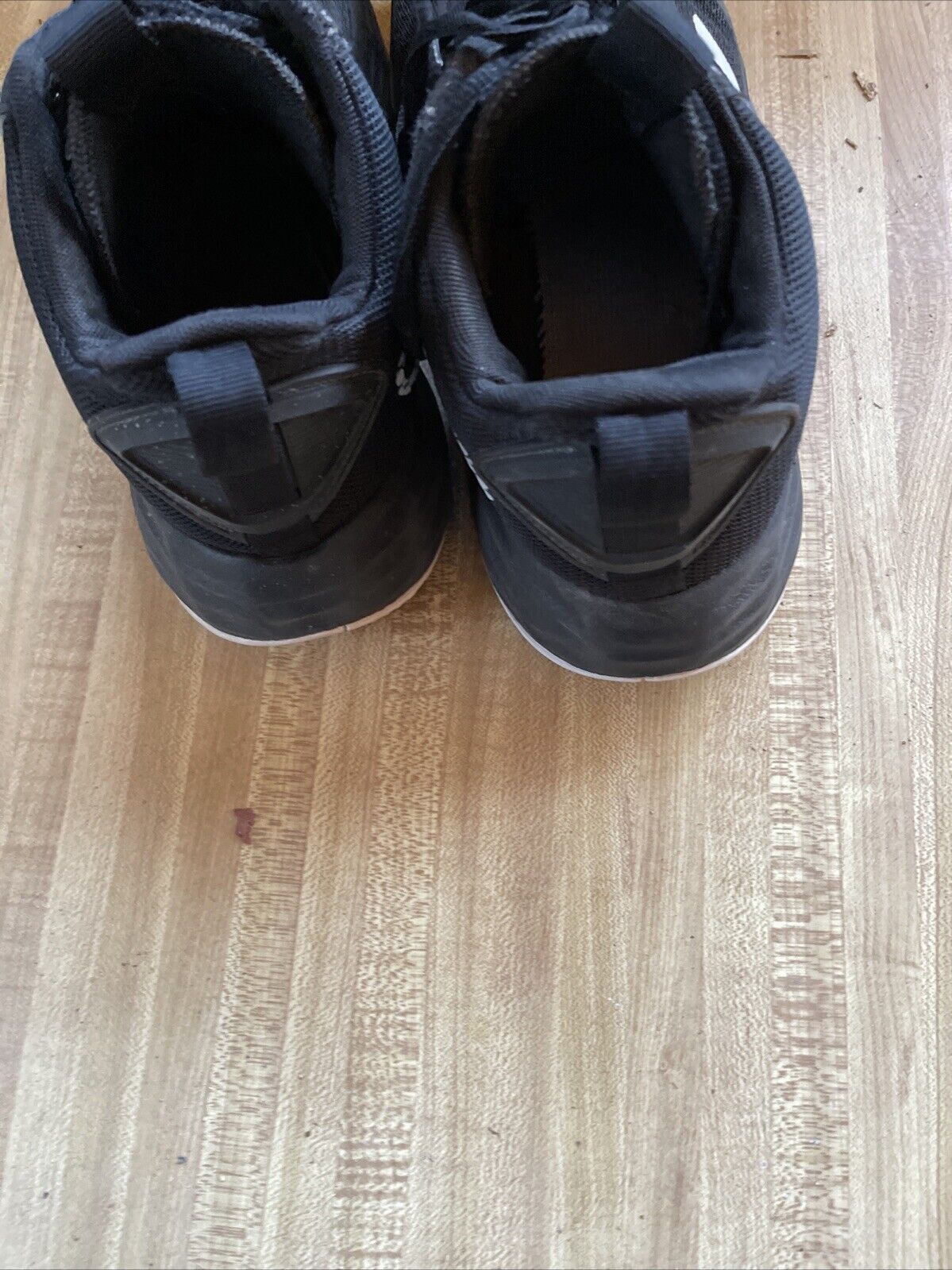 Top view of black adidas lightmotion size 11 shoes on wooden floor by 1118 Emporium
