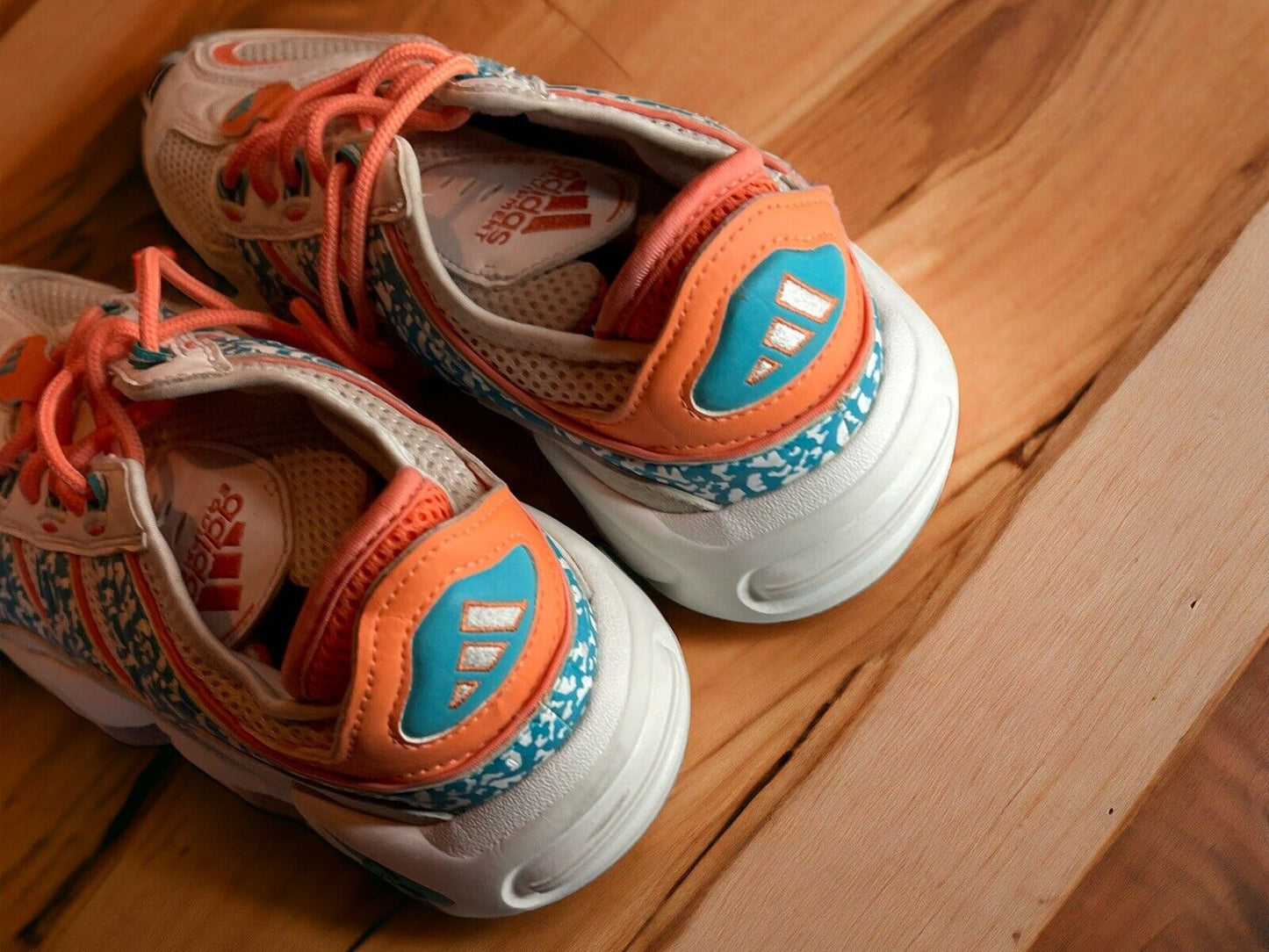 Adidas Originals FYW S-97 sneakers in white with orange and blue accents on wooden floor