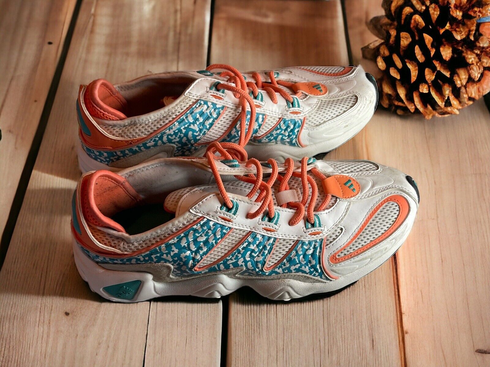 Adidas Originals FYW S-97 sneakers in white with orange and teal accents on wooden floor