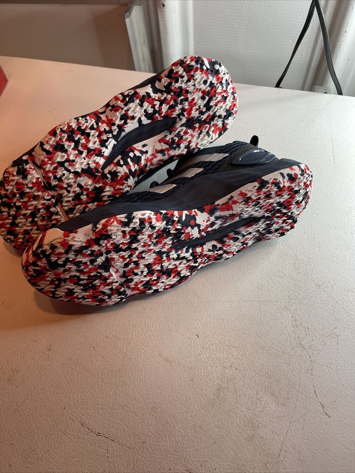 Adidas SM Exhibit A Team USA shoes showing black upper and red white black patterned soles
