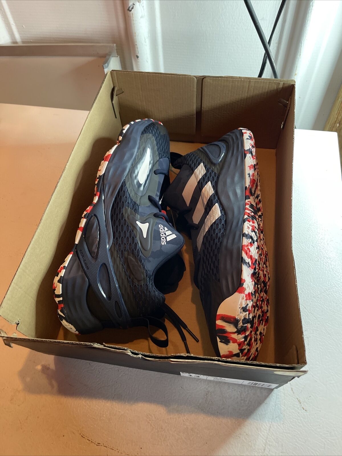 Adidas SM Exhibit A Team USA sneakers in black with red and white patterned soles inside a cardboard box