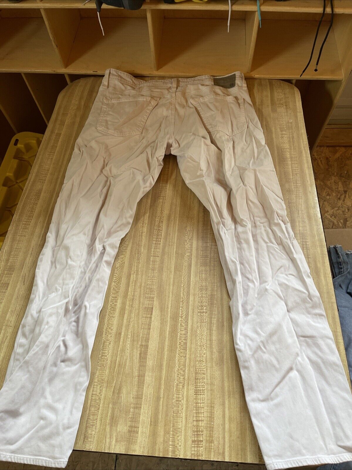 Light beige Adriano Goldschmied pants 36x32 laid flat on wooden table showing back view