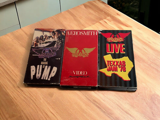Aerosmith VHS collection featuring three classic concert and video tapes on a wooden surface