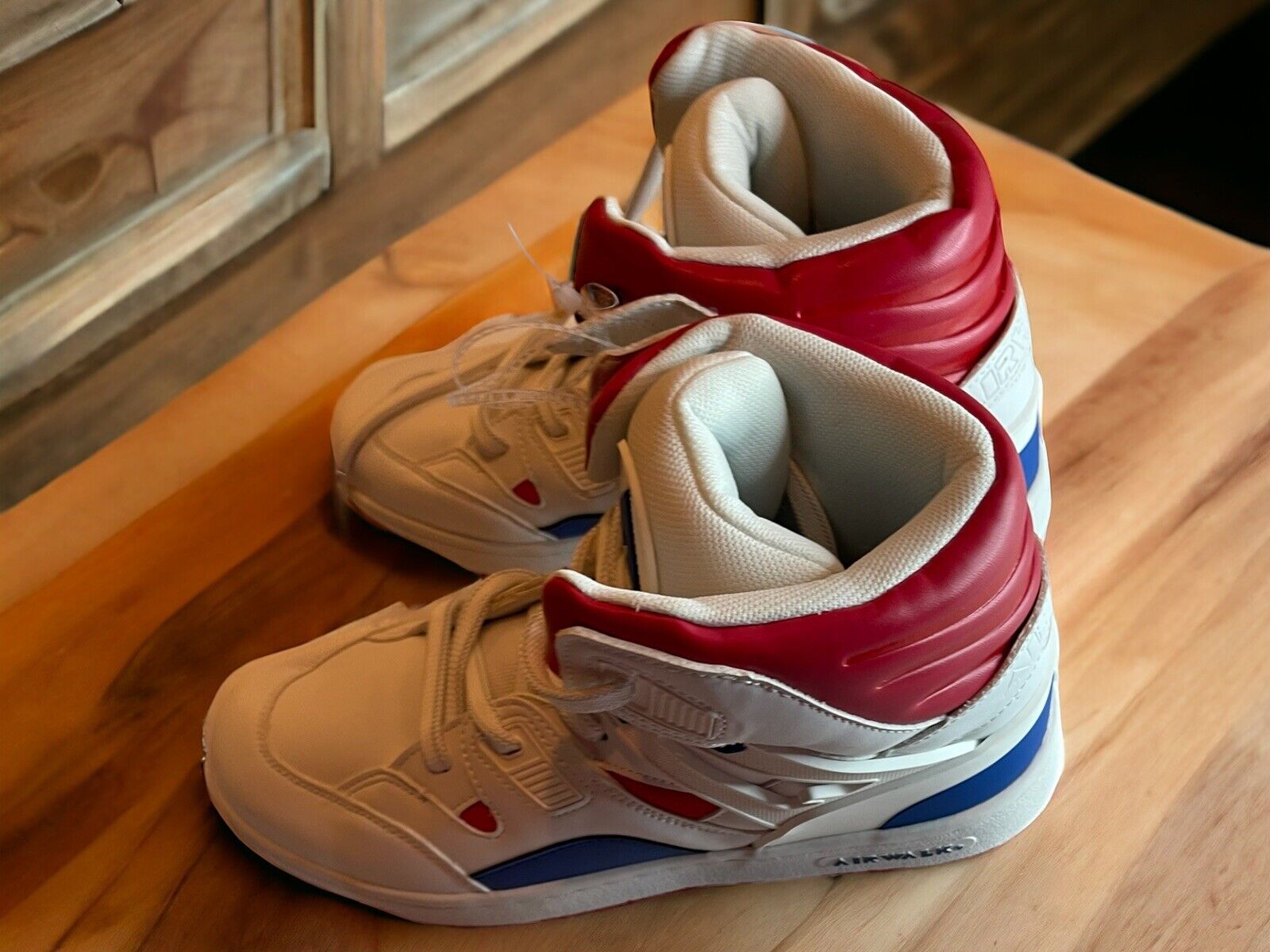 Airwalk men’s sneakers size 10 in white with red and blue accents on a wooden surface